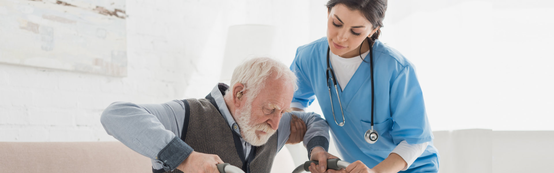 caregiver helping senior man stand up